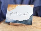 Postkarte „Glückwunsch“ | Gratulationskarte für Geburtstag, Geburt, Abschluss, herzliche Glückwünsche. Aquarelloptik mit Handlettering,